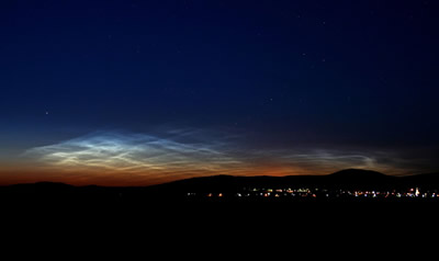 <a href="/earth/Atmosphere/NLC.html">Noctilucent</a>
  clouds are the highest clouds in the sky, but they are not associated with
  weather like the <a
  href="/earth/Atmosphere/clouds/cloud_types.html">other
  clouds</a> we regularly see in the sky. Noctilucent clouds form very high in
  the <a href="/earth/Atmosphere/overview.html">atmosphere</a>,
  in the <a
  href="/earth/Atmosphere/mesosphere.html">mesosphere</a>.
  They are best seen from Earth at sunset. This image was taken on June 15,
  2007, in Budapest, Hungary. Normally seen from locations near the <a
  href="/earth/polar/polar.html">poles</a> of
  the Earth, in recent years they have also been seen at much lower-latitude
  locations.<p><small><em> Image Courtesy of NASA/Veres Viktor</em></small></p>